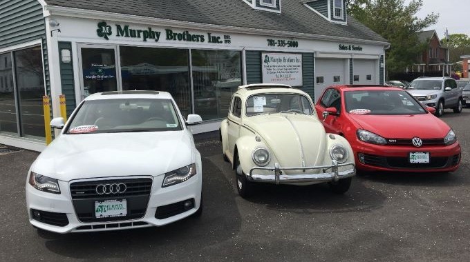 Closeup of the Weymouth shop with three vehicles for sale